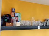 Theeproducten waaronder glazen, onderzetters en thee op schap. - afbeelding 1 van  2