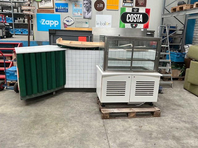 Toonbank met gebaksvitrine, witte tegelafwerking en speelse stootkussens - afbeelding 1 van  8