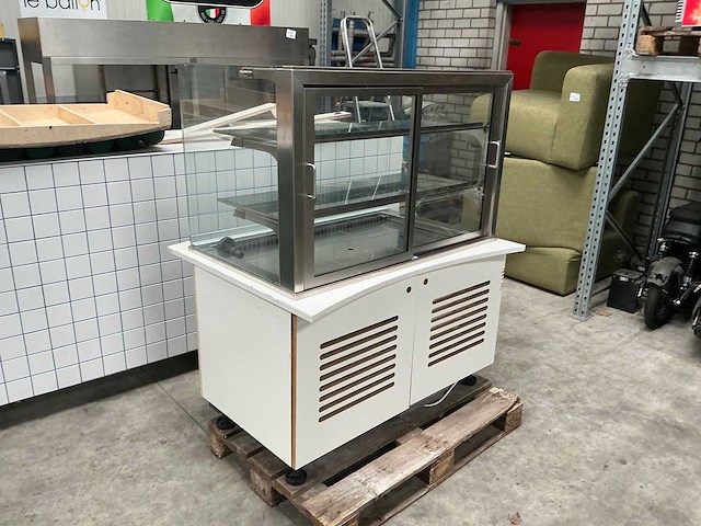 Toonbank met gebaksvitrine, witte tegelafwerking en speelse stootkussens - afbeelding 2 van  8