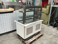 Toonbank met gebaksvitrine, witte tegelafwerking en speelse stootkussens - afbeelding 2 van  8