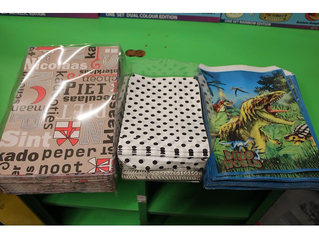 Twee aangebroken rollen kadopapier op houder en diverse papieren geschenkzakjes - afbeelding 2 van  4