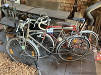 Twee fietsen, bestaande uit een herenfiets met spatborden en bagagedrager, en een racefiets met racestuur. - afbeelding 1 van  1