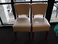 Twee stoeltjes met kunstlederen bekleding.