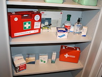 Verbandmiddelen op 2 schappen w.o. koffer, pleisters en oogdouche. - afbeelding 1 van  3