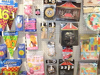 Verjaardags accessoires aan twee en halve wandschappen w.o. slingers, ballonen, tafelkleden en banners. - afbeelding 1 van  3