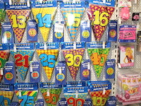 Verjaardags accessoires aan twee en halve wandschappen w.o. slingers, ballonen, tafelkleden en banners. - afbeelding 2 van  3