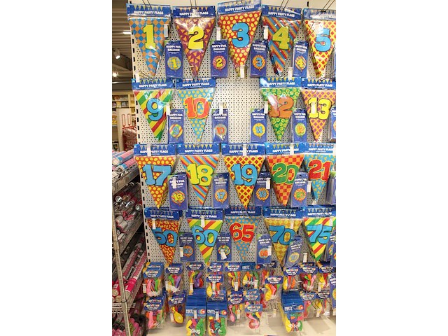 Verjaardags accessoires aan twee en halve wandschappen w.o. slingers, ballonen, tafelkleden en banners. - afbeelding 3 van  3