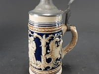 Vintage duitse keramische bierpul met kobaltblauw reliëf en een tinnen deksel